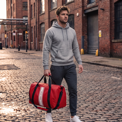 Man carrying the Atley James red duffel on a city street